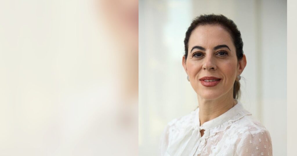 Dra. Renata Mitelman, dermatologista em Perdizes, São Paulo, sorrindo, com os cabelos soltos